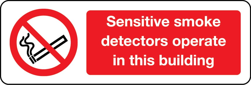 Sensitive smoke detectors operate in this building sign