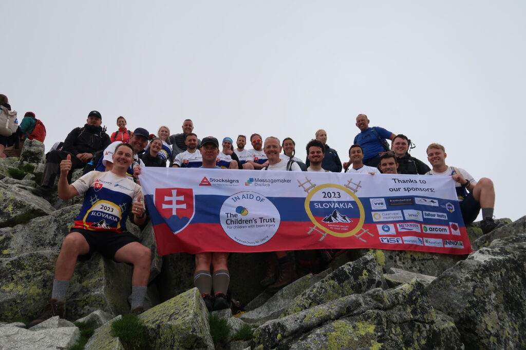 Slovakia Summits 2023 - The crew pose at the top of the mountain with the Charity banner