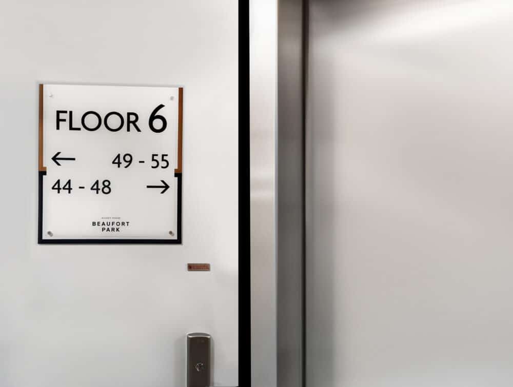 A Wayfinding sign next to an elevator, directing to flat numbers on floor 6