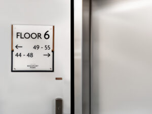 A Wayfinding sign next to an elevator, directing to flat numbers on floor 6